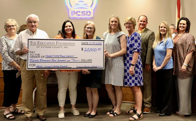 The Education Foundation of Putnam County presents a $20,500 check to the Putnam County School District Tuesday to support improved reading skills in schools. 