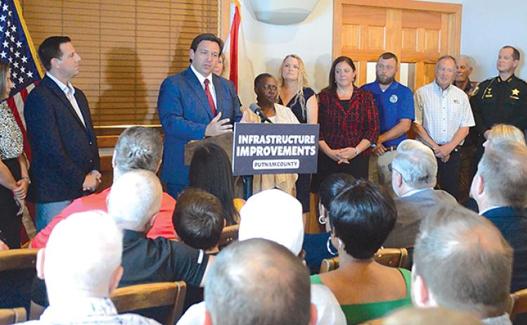 Gov. Ron DeSantis, flanked by Welaka officials, speaks Thursday during his visit to Corky Bell’s in East Palatka, where he announced more than $3 million in state funds is being allocated to pay for upgrades to the town’s wastewater treatment plant.
