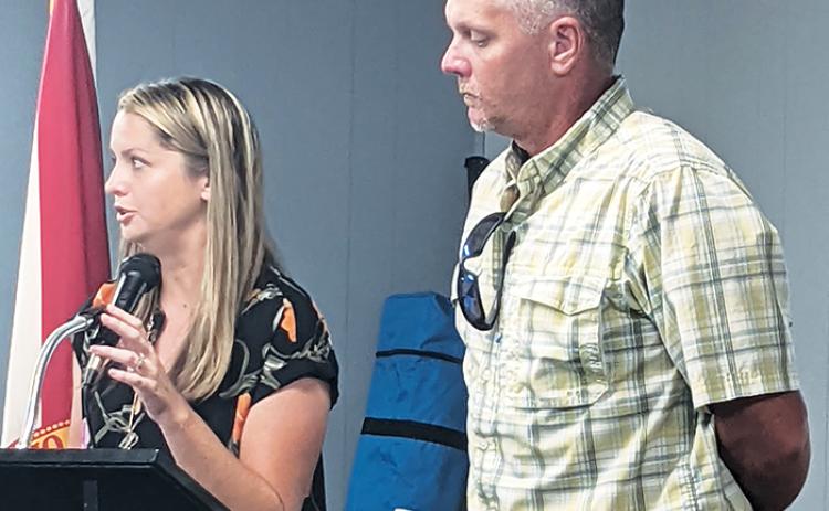 Kimberly Mann, left, and Travis Woods, employees of the Putnam County School District, discuss an anomalous water meter reading during the Interlachen Town Council meeting Tuesday.