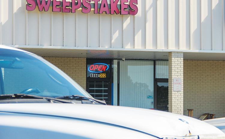 The Sweepstakes Internet Cafe in Interlachen has its windows blacked out as the open sign flashes early Tuesday morning after the Interlachen Town Council approved ousting simulated gambling devices.