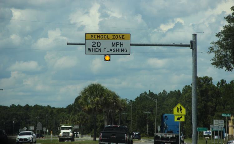 A school zone light flashes near James A. Long Elementary School on Thursday afternoon after two students reportedly brought toy guns to school.
