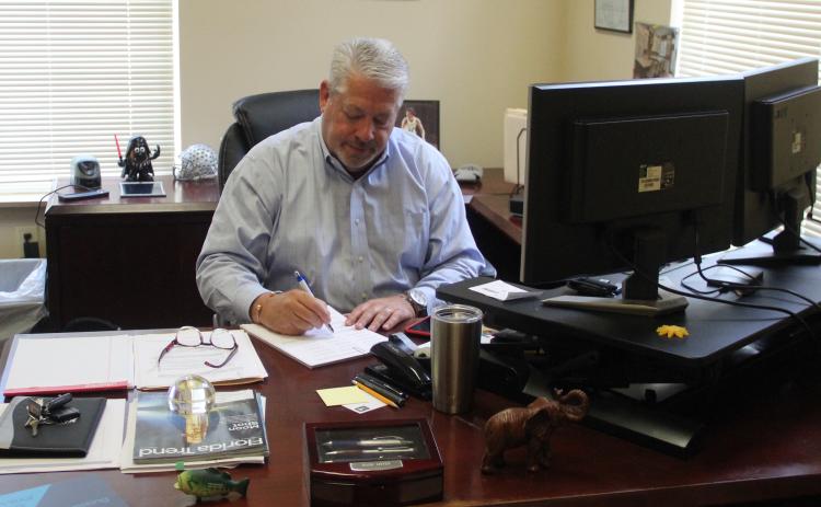 Mark Litten, the new vice president of economic development for the Putnam County Chamber of Commerce, examines paperwork at his desk Monday morning.