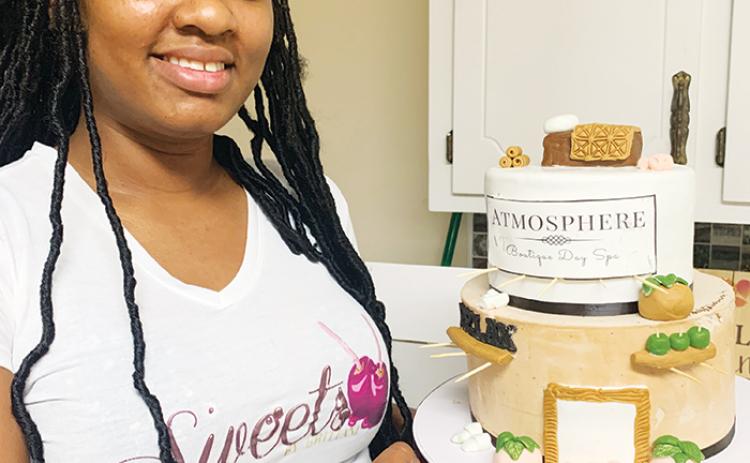 Brittani Wellon, owner of Sweets by Brittani LLC, holds the in-progress version of a  cake she worked on for Palatka-based Atmosphere Boutique and Spa’s second anniversary.