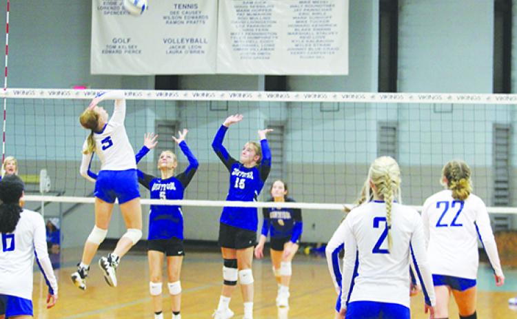 Peniel Baptist Academy’s Alexis Wallace goes high for a kill attempt against Countryside Christian’s Adysan Keith (5) and Delaney Robertson. (MARK BLUMENTHAL / Palatka Daily News)