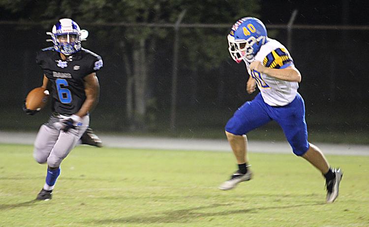 Interlachen’s Rickey Astin looks for room to run as Fernandina Beach’s Trey Foote tries to chase him down during the second quarter. (MARK BLUMENTHAL / Palatka Daily News)
