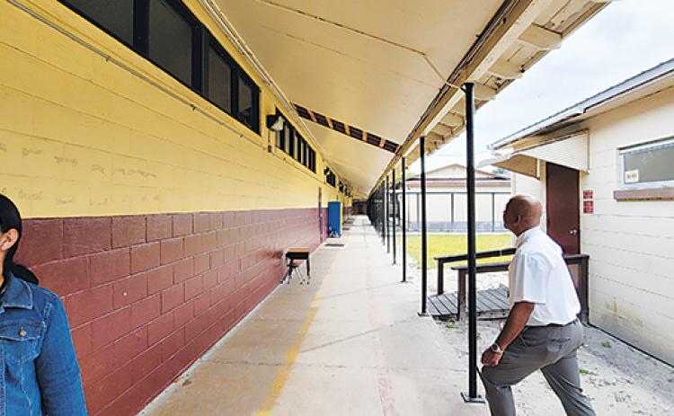 Thomas Bolling, right, assistant superintendent for support services, examines areas of Middleton-Burney Elementary School that are in need of repairs.