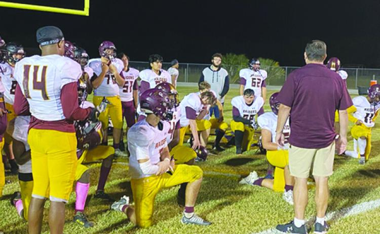 Dejected Crescent City players listen to head coach Sean Delaney (right with back turned) after a 30-28 loss to Lake Weir. (Corey Davis / Palatka Daily News)