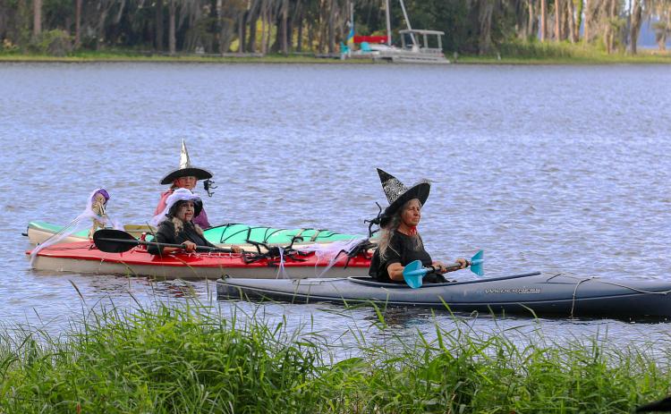 Three witches take their kayaks across Lake Santa Fe on Friday during this year's witches paddle in Melrose. (SARAH CAVACINI/Palatka Daily News)