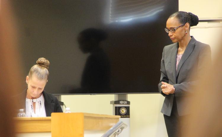 Assistant Public Defender Rosemarie Peoples watches as witness Chrisy Adkins reviews documents Wednesday.