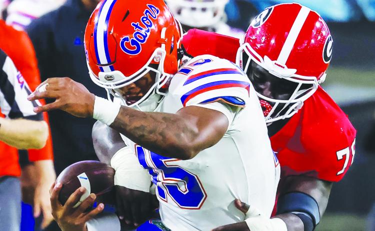 Florida quarterback Anthony Richardson is grabbed from behind by Georgia’s Nazir Stackhouse during Saturday’s game at T.I.A.A. Bank Field. (JOHN STUDWELL / Special to the Daily News)