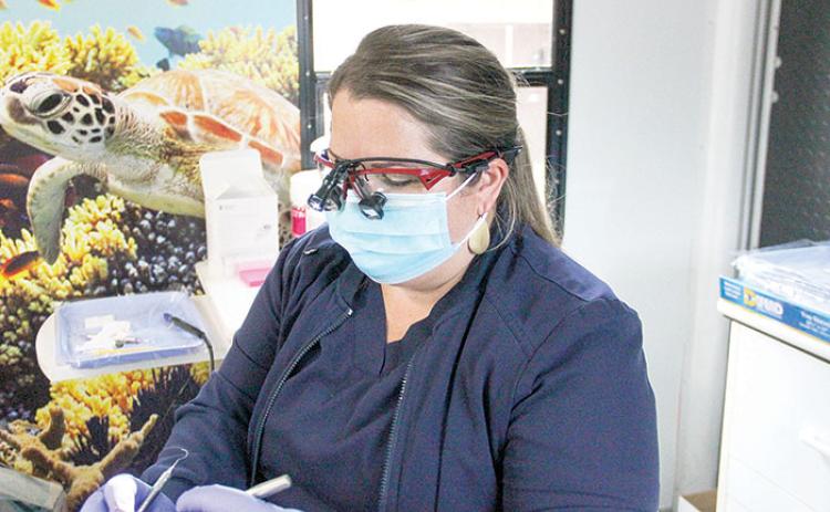 Dental hygienist Lindsey Stein cleans a patient’s teeth in Interlachen on Monday.