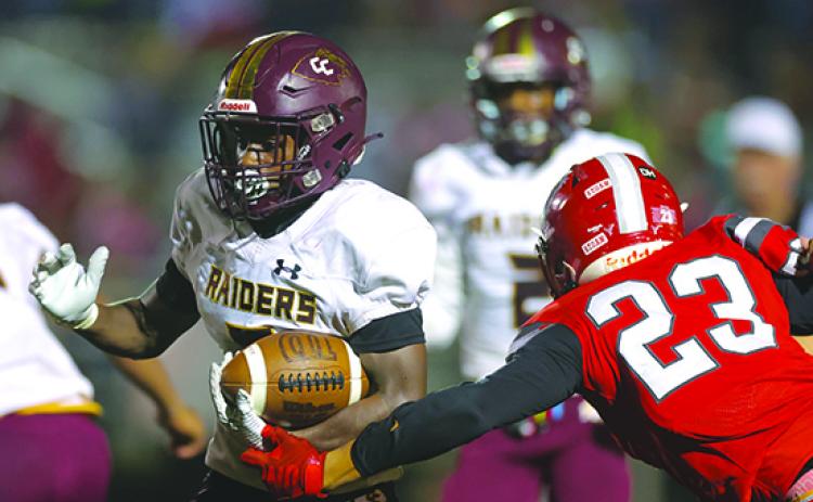 Crescent City’s Ray Davis charges up the middle for a gaine as Bradford’s Tray Schmitt gets an arm on him Friday night. (JAMES GILBERT / Special to the Daily News)