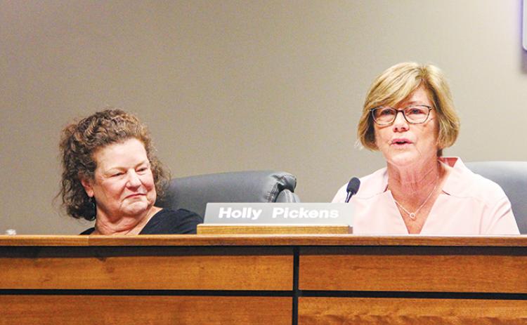During her final meeting, school board member Jane Crawford, left, looks at board Chairwoman Holly Pickens as she talks Tuesday afternoon.