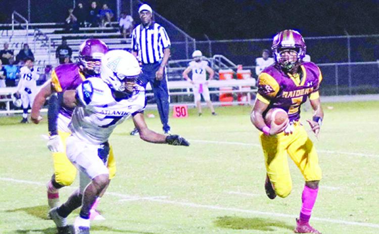 Crescent City’s Eric Jenkins Jr., here looking for yards while being chased by Port Orange Atlantic’s Preston Kuznof during the Raiders’ 35-28 win on Oct. 14, has grown into the starting quarterback job as a sophomore. (RITA FULLERTON / Special to the Daily News)