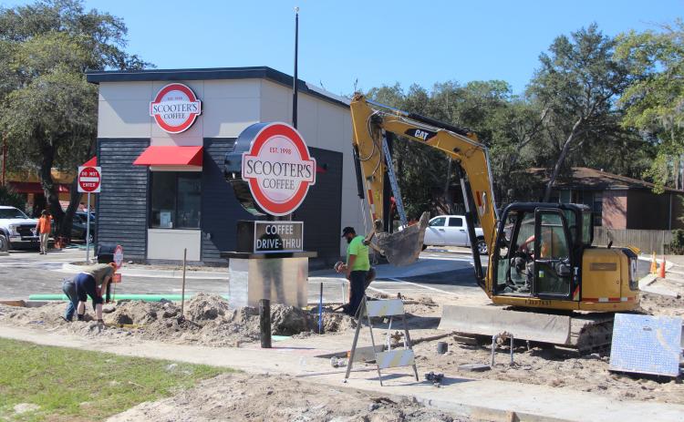 Construction workers work to finish a Scooter's Coffee on State Road 19 that is expected to open in a few weeks.
