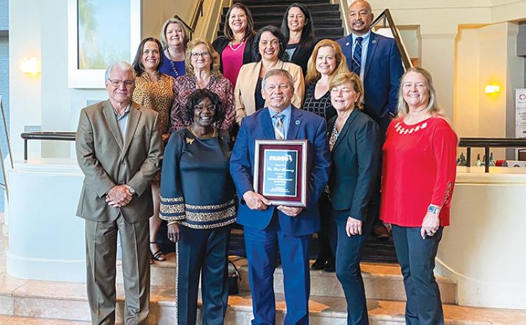 Putnam County School Board members and other district officials share a moment with Superintendent Rick Surrency, center, Wednesday after he was named the Superintendent of the Year by the Florida Association of District School Superintendents.
