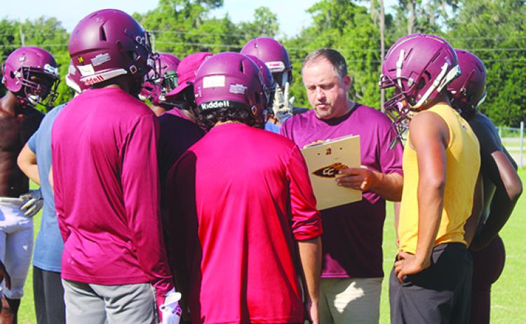 Crescent City Junior-Senior High School football coach Sean Delaney goes over the offense with his team at practice last August. (MARK BLUMENTHAL / Palatka Daily News)