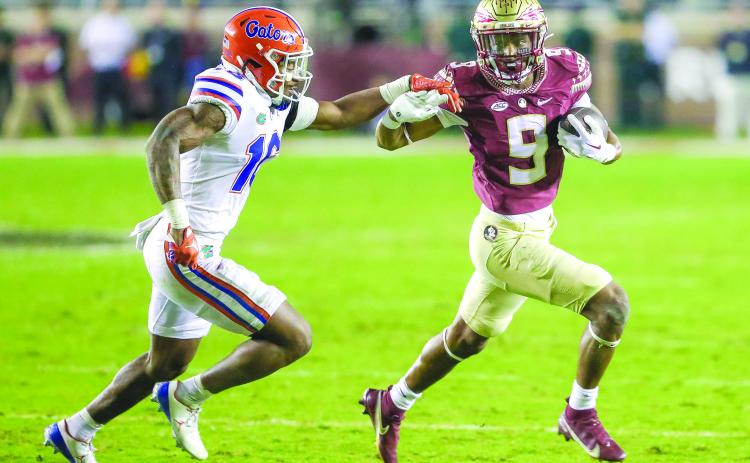 Florida State’s Lawrence Toafili tries outrun Florida’s Tre’Vez Johnson during Friday night’s game at Doak Campbell Stadium. (GREG OYSTER / Special to the Daily News)