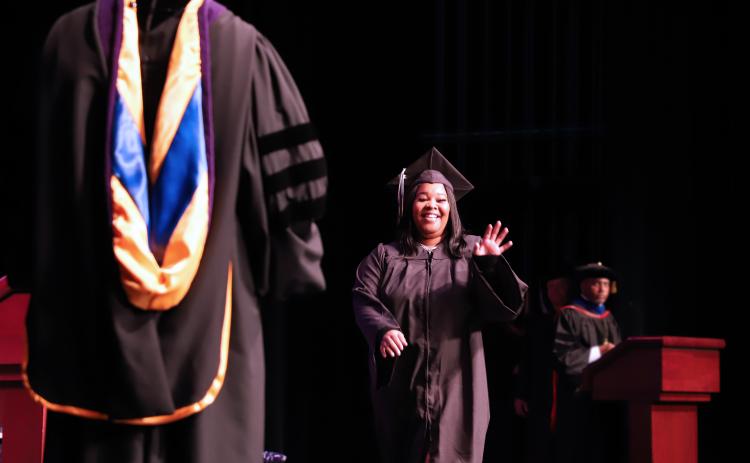 Na’Teria Hamilton walks across the stage at St. Johns River State College Thrasher-Horne Center to receive her diploma from college President Joe Pickens, left. (Susan Kessler/St. Johns River State College)