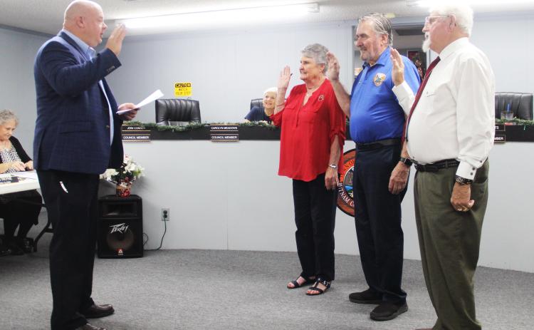 Interlachen Town Attorney George Young on Tuesday swears in, from left to right, Town Council Member Joni Conner, Mayor Ken Larsen and newly elected Town Council Member David Yonts.