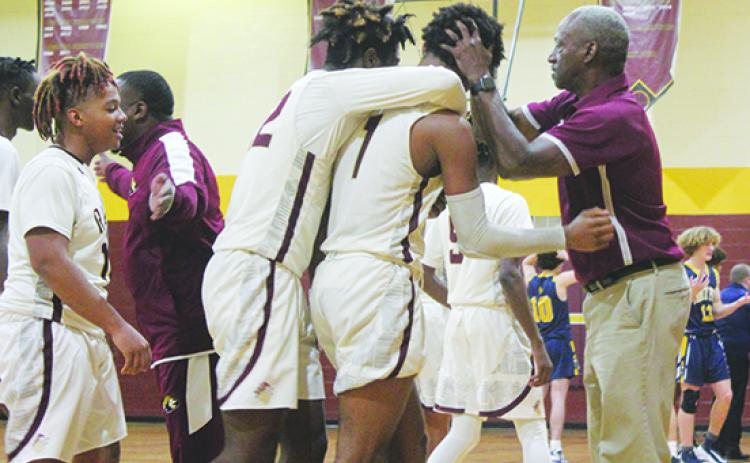 Crescent City Junior-Senior High School boys basketball coach Al Carter celebrates his 300th career win with Lentavius Keenan after Keenan hit the game-winning, 3-point field goal to beat Winter Park Trinity Prep, 48-47, Saturday. Behind Keenon is teammate Freddie Major. (MARK BLUMENTHAL / Palatka Daily News)