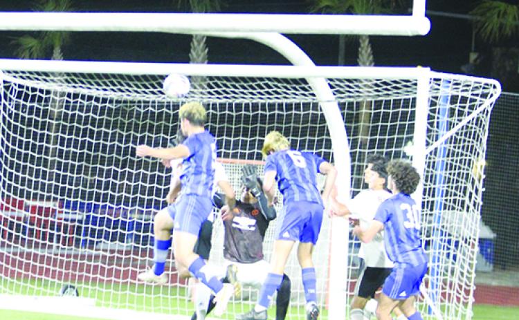 olles School’s Luke Santamaria (5) goes high for a headball and scores his team’s first goal against Crescent City Wednesday night. (MARK BLUMENTHAL / Palatka Daily News)