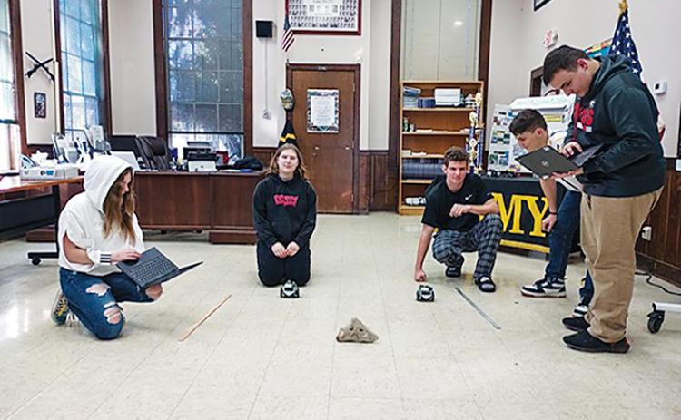 Interlachen Junior-Senior High School JROTC robotics team members compete against one another by coding and racing around an object.