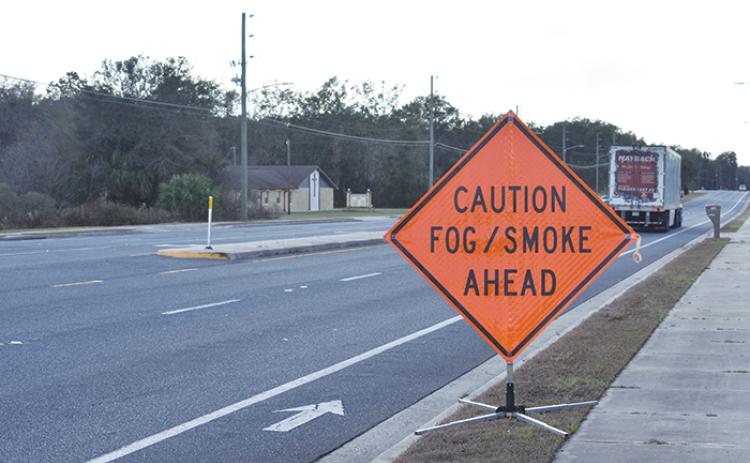 A sign warning of fog and smoke stands at the intersection of State Road 20 and Francis Church Road on Wednesday, a day after a fire occurred in the area.