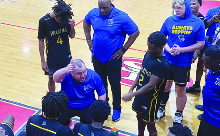 Palatka boys basketball coach Bryan Walter (kneeling) talks to his players during a second-half timeout Wednesday night against North Marion. (COREY DAVIS / Palatka Daily News)
