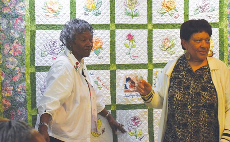 Targie Rhim, left, stands in front of a quilt she constructed to show off at “Metamorphosis II, The Evolution of the Black Artist,” a Black history art display at the Larimer Arts Center in Palatka.