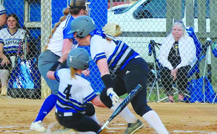 Interlachen’s Saige Culpan (4) scores on a first-inning, third-strike passed ball as teammate Kaitlyn Dillard heads to first base and Peniel pitcher Lexi Peacock waits for the ball at home plate. (RITA FULLERTON / Special to the Daily News)