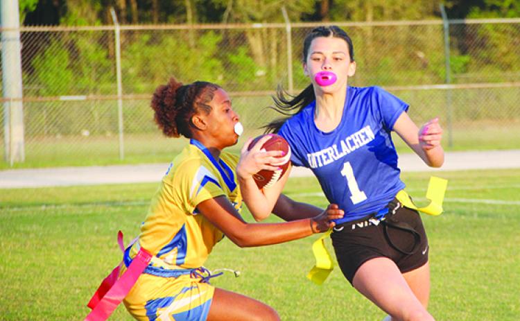 Interlachen’s Paislee Guessford tries to elude the flag pull attempt of Palatka’s Charity Givens during Thursday’s game. (COREY DAVIS / Palatka Daily News)