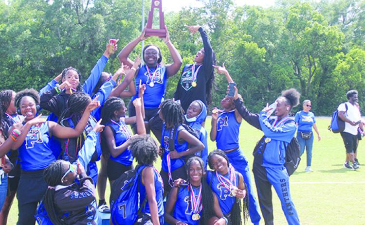 Tamia Wiggins holds the championship trophy up high as she and her Palatka Junior-Senior High School girls track team celebrate their second-straight District 5-2A championship Friday. (MARK BLUMENTHAL / Palatka Daily News)