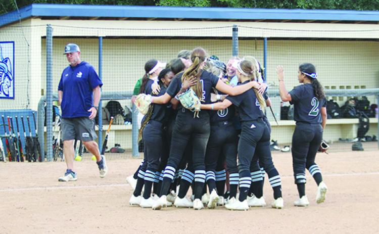 St. Johns River State College softball coach Joe Pound (left) walks back to his team’s dugout as Lake-Sumter State College players celebrate winning the Sun-Lakes Conference regular-season title with a 2-0 win Tuesday. (MARK BLUMENTHAL / Palatka Daily News)