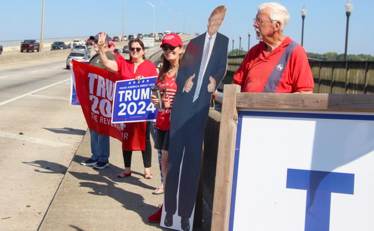 Republican Club of Putnam County members wave Tuesday to people drive on the Palatka Memorial Bridge as they rally behind former President Donald Trump. (SARAH CAVACINI/Palatka Daily News)