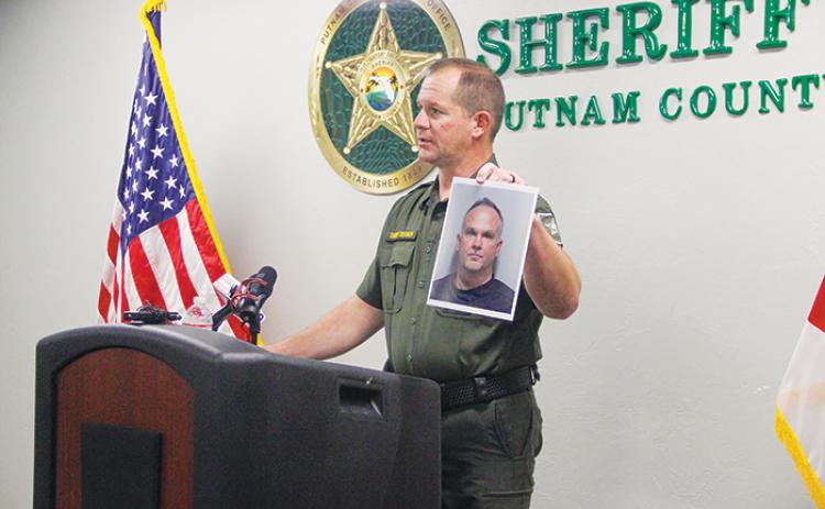 Sheriff Gator DeLoach holds the mugshot of Edward Wilds III, a teacher accused of child porn possession, during a press conference April 14. 