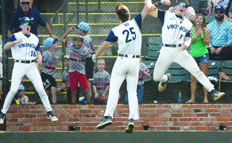 Andon Lewis (25) celebrates scoring a fifth-inning run against Heartland with teammates Jake O’Steen (1) and Cole Steinmetz. (BILLY HEFTON / Enid News and Eagle)