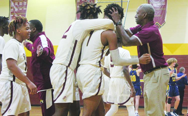 Above, Crescent City’s Lentavious Keenon (1) is congratulated by teammate Freddie Major (behind him) and coach Al Carter after hitting the game-winning 3-point field goal to beat Winter Park Trinity Prep, 48-47, on Jan. 7 for Carter’s 300th career victory. (MARK BLUMENTHAL / Palatka Daily News)