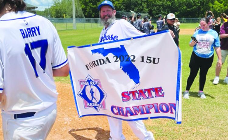 Dale Yarbrough holds the North Florida 15-and-under Babe Ruth baseball all-star championship flag after his team won the title last year. (MARK BLUMENTHAL / Palatka Daily News)