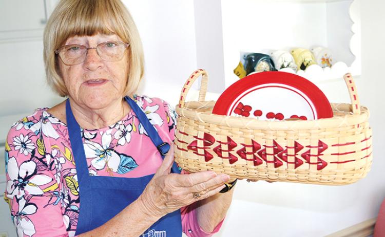 Irene Bowie of Satsuma holds a handmade biscuit basket she made. Bowie has donated some of her baskets to the St. Monica Catholic Church Ladies Guild’s Christmas in July Holiday Market that will take place Friday and Saturday.