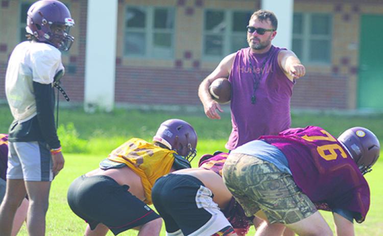 Crescent City assistant coach and athletic director Tim Ross points to offensive linemen while looking at Raiders quarterback Eric Jenkins Jr. in practice. (MARK BLUMENTHAL / Palatka Daily News)