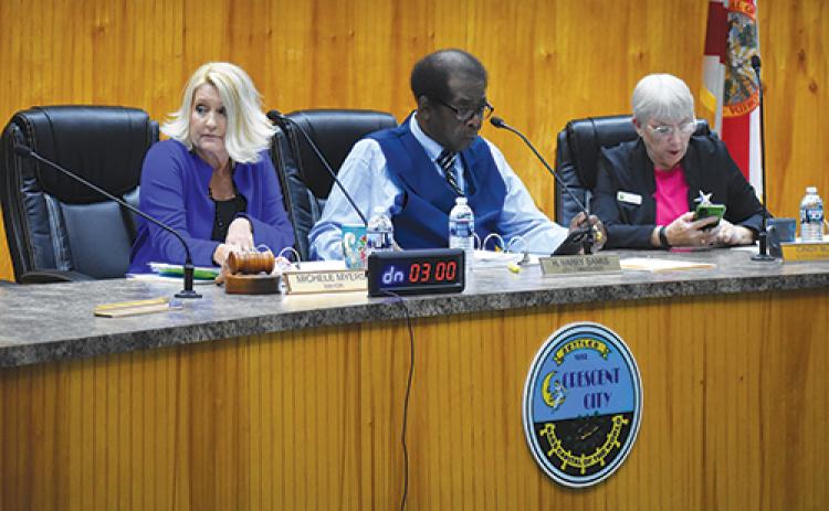 BRANDON D. OLIVER/Palatka Daily News -- From left, Crescent City Mayor Michele Myers and Commissioners Harry Banks and Cynthia Burton check their schedules Monday as they look for another date to resume the meeting that was cut short.