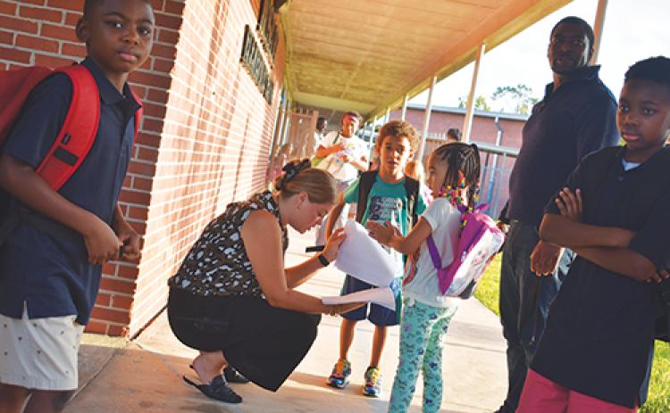 BRANDON D. OLIVER/Palatka Daily News -- Shelby Bellamy, an instructional support coach at Moseley Elementary School, helps students find out where their classrooms are located on the first day of school.