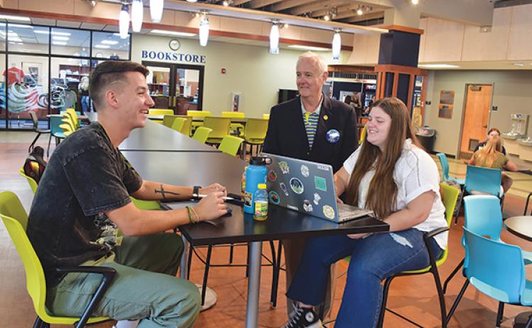BRANDON D. OLIVER/Palatka Daily News -- St. Johns River State College President Joe Pickens, standing, talks with students Michael Smith, left, and Riley Speaks on Monday, the first day of the fall semester.