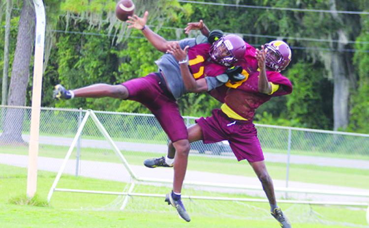 Crescent City's Arzavian Williams (right) knocks the ball away from receiver Freddy Major during a pass play in Thursday's practice. (MARK BLUMENTHAL / Palatka Daily News)