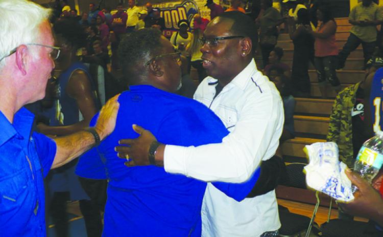 Palatka boys basketball coach Bryant Oxendine hugs assistant coach Anthony Royster (right), while receiving a pat on the back of congratulations from Palatka High athletic director Bobby Humphries after the Panthers defeated New Port Richey Ridgewood, 64-51, in Ridgewood’s last game as a program on its home court on March 2, 2018. (MARK BLUMENTHAL / Palatka Daily News)