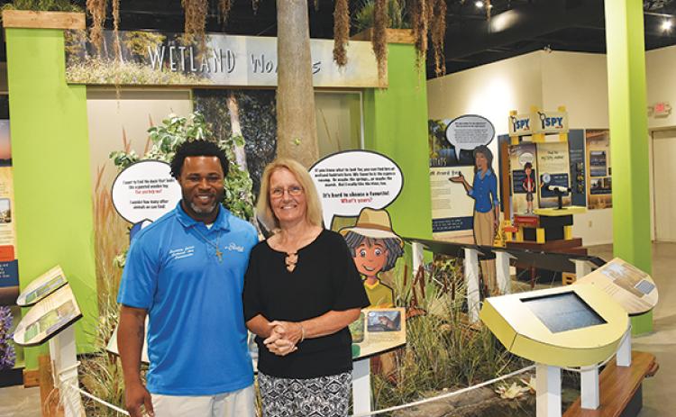 BRANDON D. OLIVER/Palatka Daily News – Cultural Arts Coordinator Courtney James, left, and Volunteer Coordinator Shann Purinton stand in front of a display at the St. Johns River Center in Palatka.