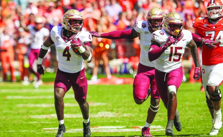 Kalen DeLoach (4) gets a pair of Florida State teammates, including Tatum Bethune, to block for him en route to a touchdown off a fumble return Saturday against Clemson. (GREG OYSTER / Special to the Daily News)