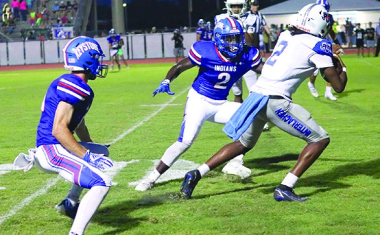 Interlachen’s Kaleb McKinnon tries to get away from Keystone Heights’ Cartez Daniels during the first half of Friday night’s game at Keystone Heights High School, won by the Indians, 46-8. (RITA FULLERTON / Special to the Daily News)