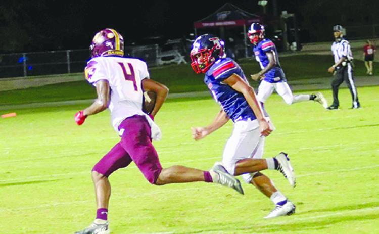 Crescent City’s Lentavious Keenon (4) runs away from Pierson Taylor’s Nikko Dozier Friday night. (RITA FULLERTON / Special to the Daily News)